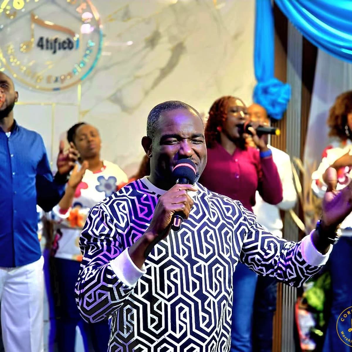 A worshipper singing into the microphone on stage